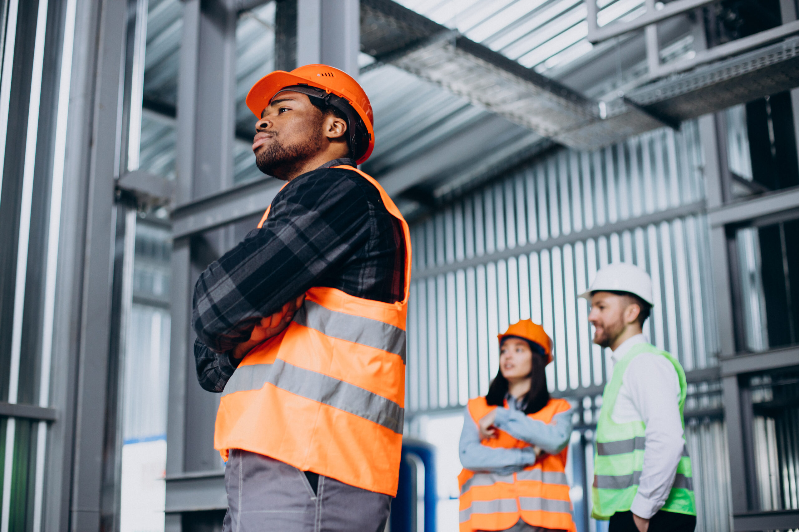 Construction workers in safety gear standing on site.