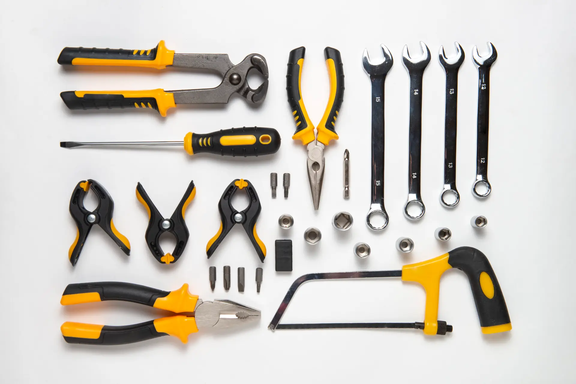 A set of yellow and black hand tools arranged on a white surface.